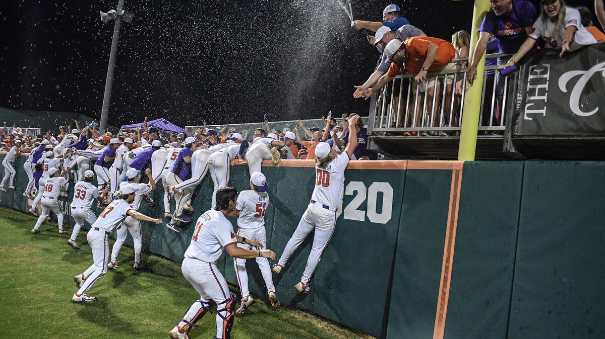 Jun 2, 2024; Clemson, South Carolina, USA; Clemson players run to the Cheap Seats section and Cajun Cafe celebrating with fans after defeating Coastal Carolina at the Clemson Regional at Doug Kingsmore Stadium.