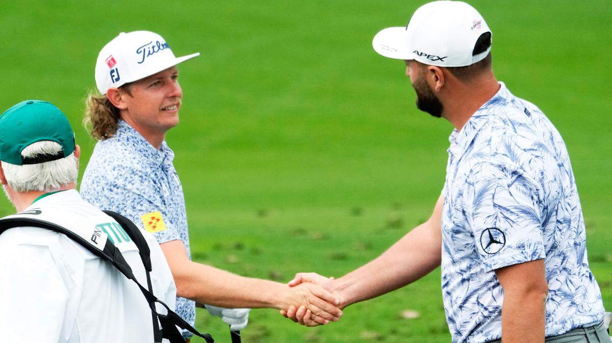 LIV Golf’s Cameron Smith and the PGA Tour’s Jon Rahm shake hands on the practice range Monday during a practice round for The Masters golf tournament at Augusta National Golf Club.