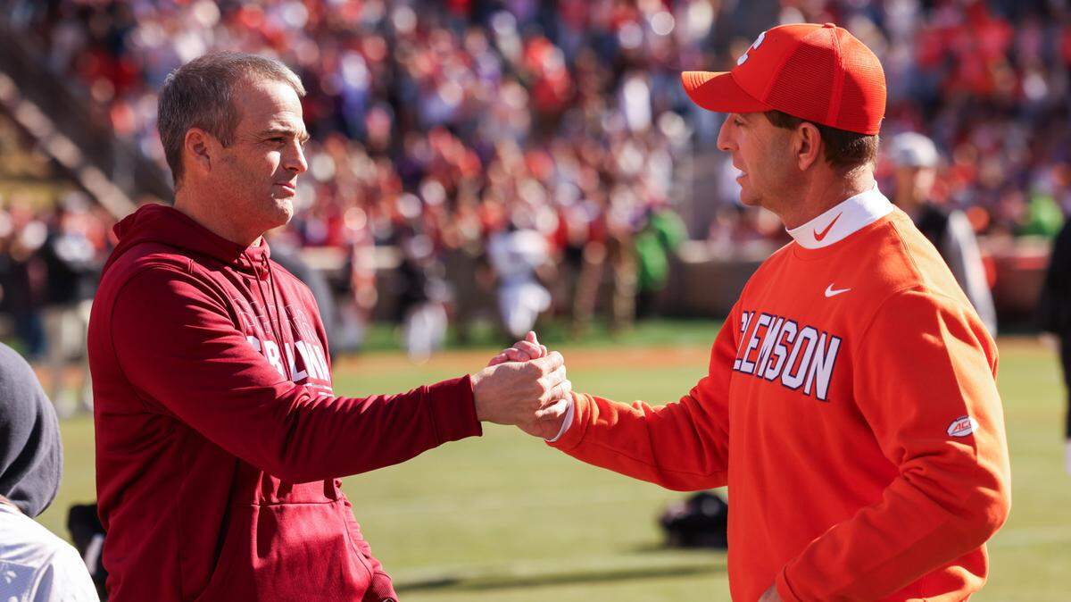 South Carolina head coach Shane Beamer speaks with Clemson head coach Dabo Swinney on the field before the Palmetto Bowl between at Memorial Stadium in Clemson on Saturday, November 30, 2024.