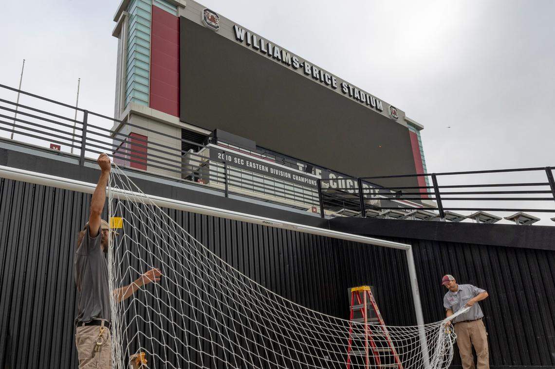 Kyle Bloxom, left, and Rusty Austin set up a soccer goal at Williams-Brice Stadium. A total of four goals will be inside the stadium for the Liverpool vs Manchester United soccer match, with two spare.
