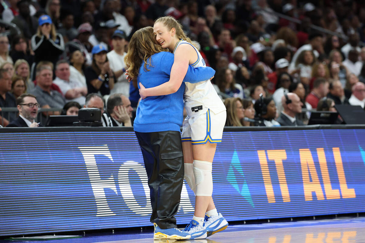 Gianna Kneepkens #8 of the UCLA Bruins embraces head coach Cori Close after she was removed from the game during the fourth quarter against the South Carolina Gamecocks in the National Championship of the NCAA Women's Basketball Tournament at Mortgage Matchup Center on April 05, 2026 in Phoenix, Arizona.