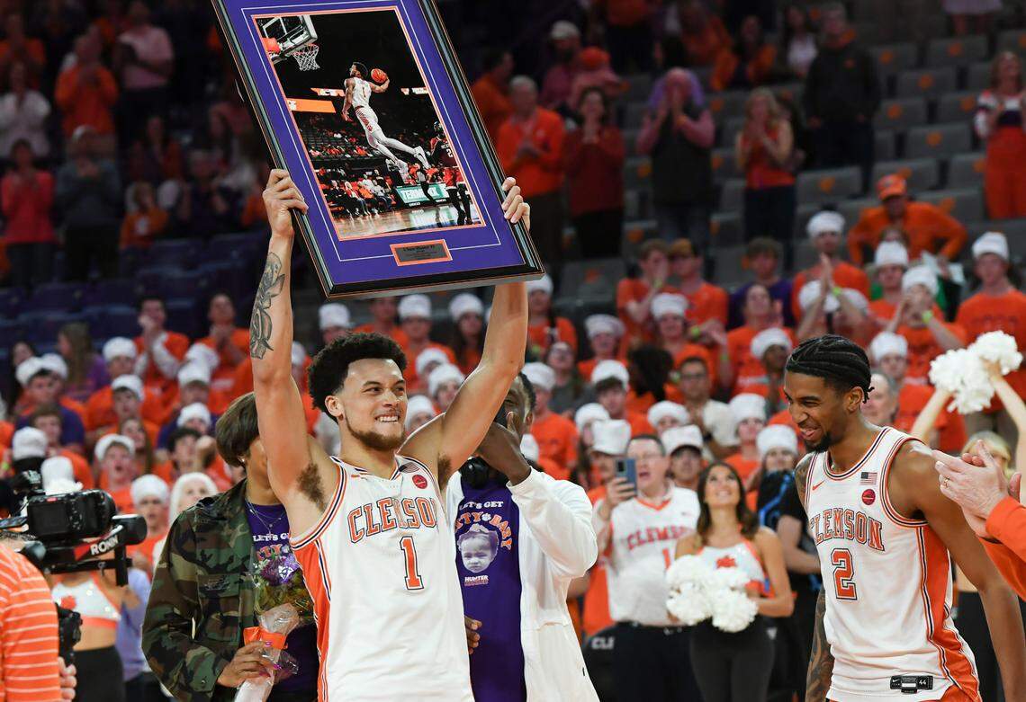 Mar 8, 2025; Clemson, SC, USA; Clemson guard Chase Hunter (1) holds up a framed photo near his brother guard Dillon Hunter (2) during the pregame senior night presentation, before tipoff at Littlejohn Coliseum in Clemson, S.C Saturday, March 8, 2025.