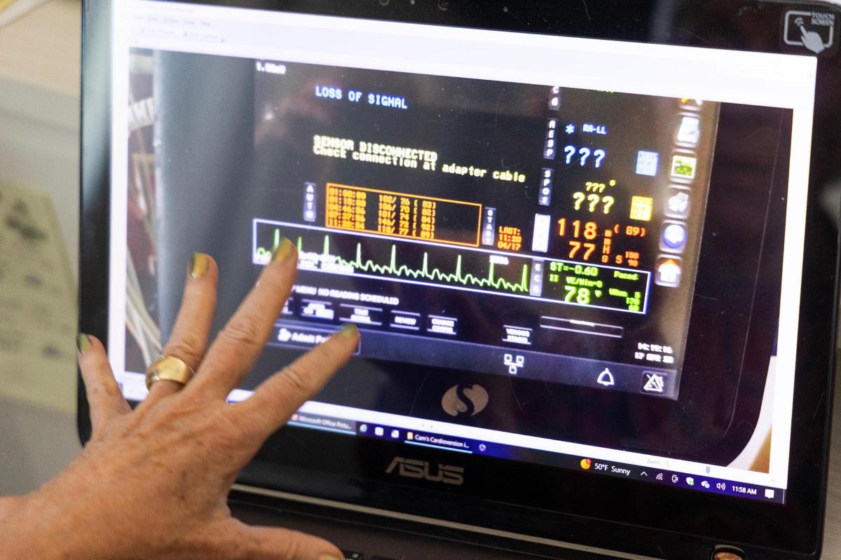 Marty Koblish shows photos of her husband Cam in urgent care for a cardiac event on Thursday, December 7, 2023. Koblish found the ambulance response time from urgent care to be excessively long, and potentially dangerous in other cardiac events.