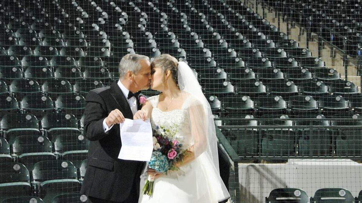 Mark Dillon Cain kisses Tanya Mullins Flake Cain after they were married at Spirit Communications Park in 2016 as a part of the USC Love Story.