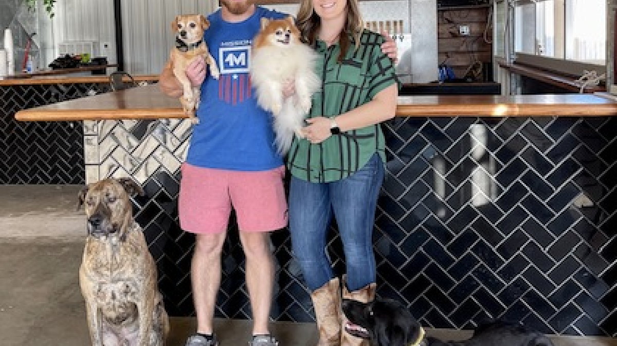 Stephanie Danielsson and Sean Martin opened The Dapper Dog in January. It is a dog training business by day and a bar at night. Also shown are Penny (Pomeranian), Cooper (chi weenie), Blu (lab-mastiff), and Athena (lab-golden mix).