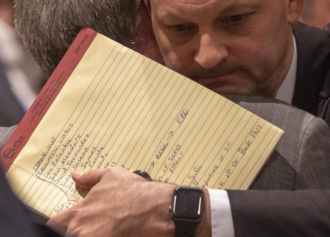 A list of names to thank are seen on the notepad of attorney general Alan Wilson as he hugs prosecutor Creighton Waters after Alex Murdaugh was found guilty on all four counts at the Colleton County Courthouse in Walterboro on Thursday, March 2, 2023. Andrew J. Whitaker/The Post and Courier/Pool