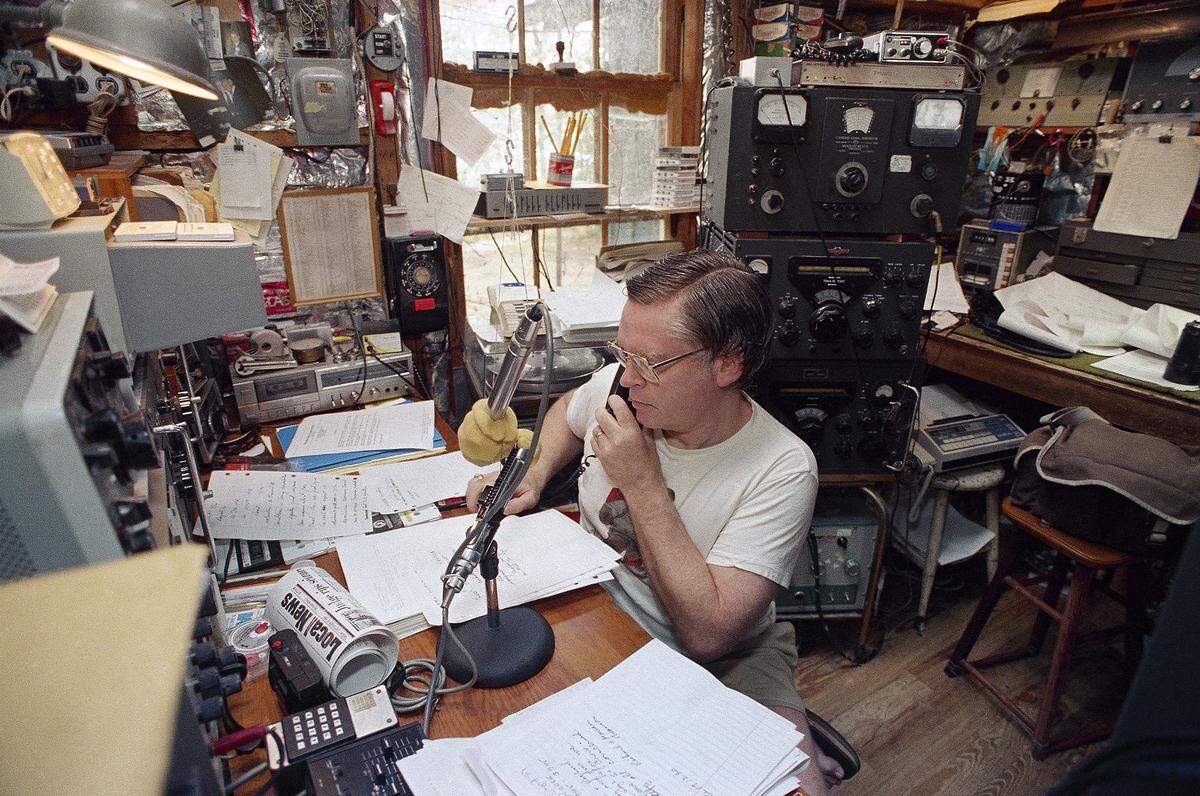 Glenn Baxter, manager of the International Amateur Radio Network, answers the phone while manning his ham radio from a small building nest to his home in Belgrade Lakes, Maine, Sept. 20, 1989. With 2,000 members in 45 countries, Baxters network helps disaster victims obtain emergency aid and contact worried relatives. Similar ham radio operators helped victims of Hurricane Hugo in the Caribbean earlier this month. (AP Photo/Herb Swanson)