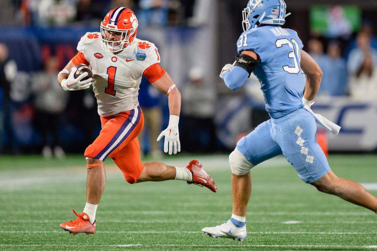 Clemson running back Will Shipley (1) carries while pursued by North Carolina defensive back Will Hardy (31) during the first half of the the Atlantic Coast Conference championship NCAA college football game Saturday, Dec. 3, 2022, in Charlotte, N.C. (AP Photo/Jacob Kupferman)