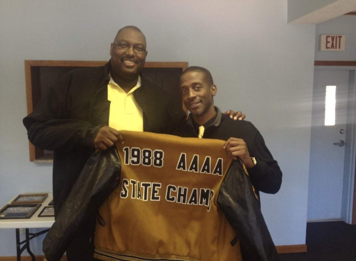 Former high school teammates Stanley Roberts and Jo Jo English pose with a jacket to signify Lower Richland’s 1988 state title.