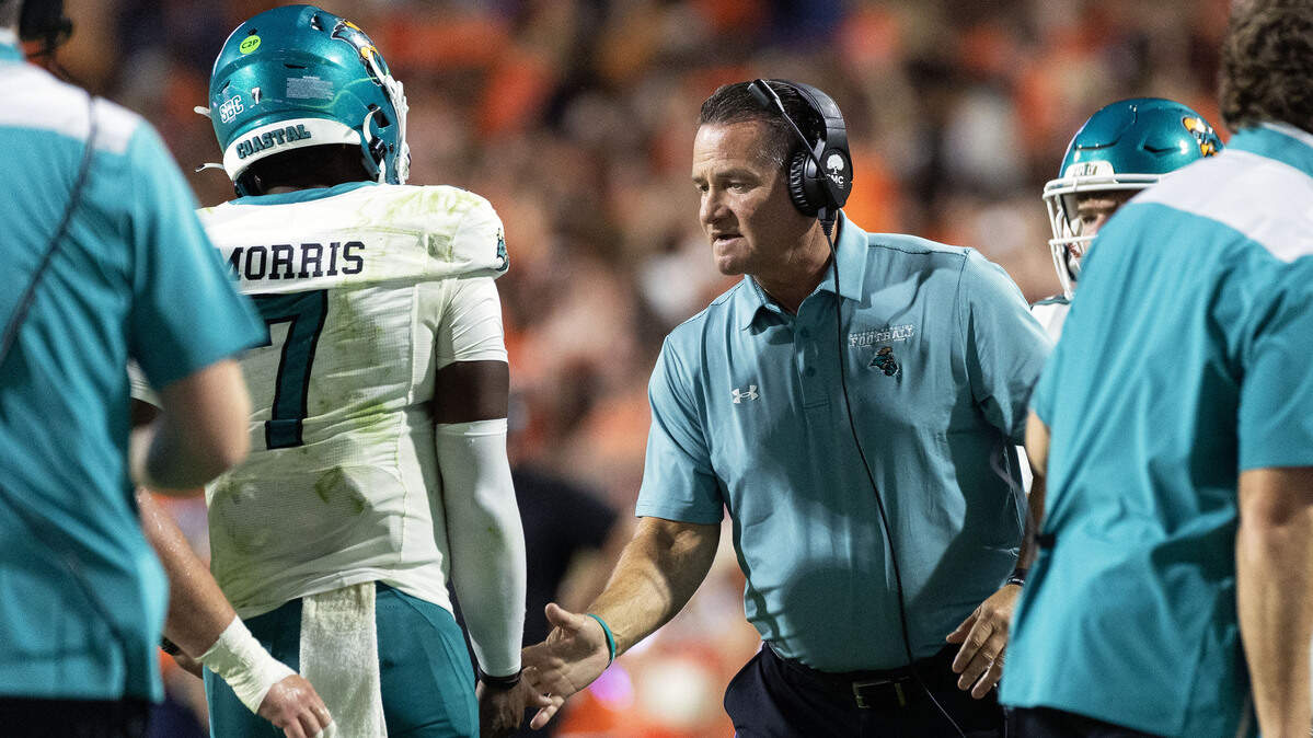 Head coach Tim Beck of the Coastal Carolina Chanticleers talks to MJ Morris #7 in the second half during the game against the Virginia Cavaliers at Scott Stadium on August 30, 2025 in Charlottesville, Virginia.