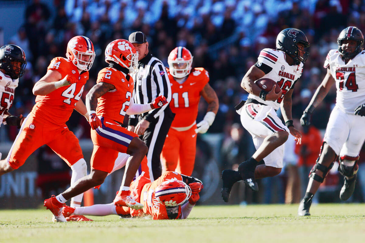 University of South Carolina quarterback LaNorris Sellers (16) avoids being tackled by Clemson safety Khalil Barnes (7) on Saturday, November 30, 2024.