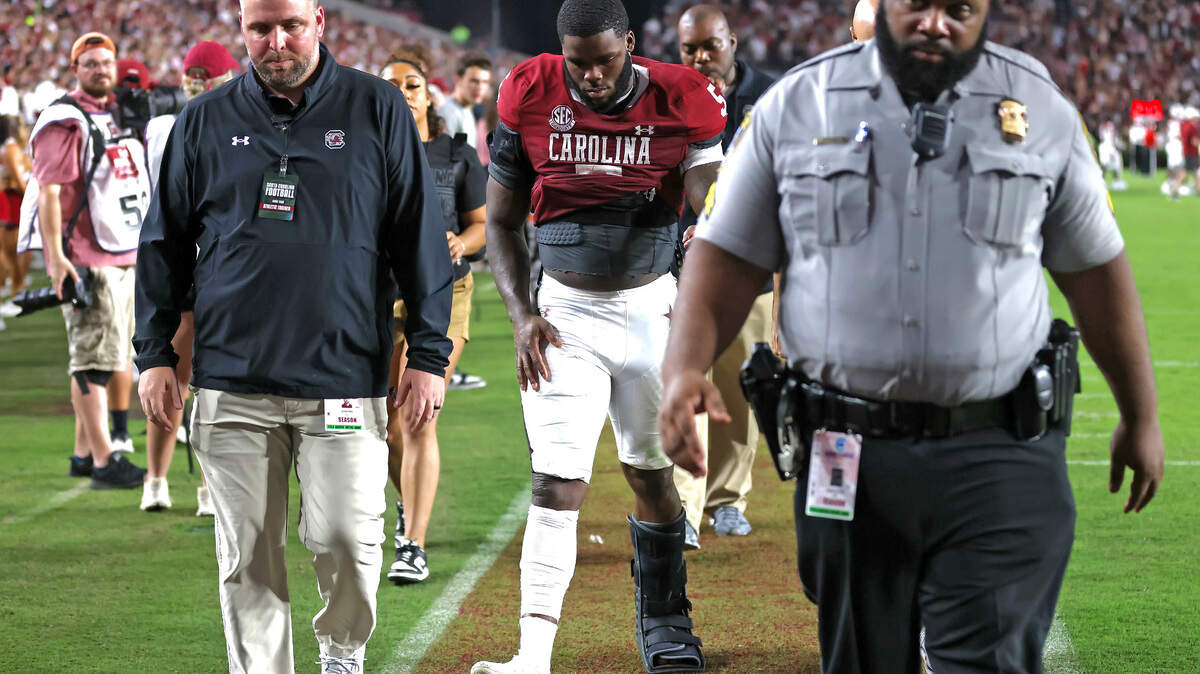 Rocket Sanders heads to the locker room before halftime with a walking boot on his left foot.