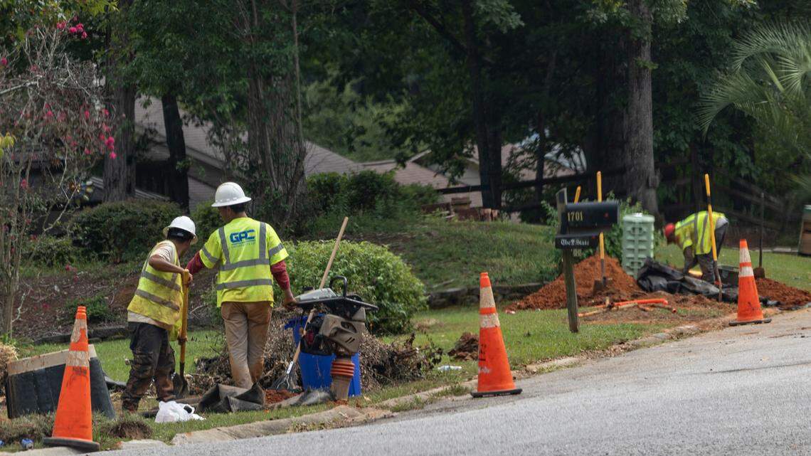 Workers with GAC Enterprises, LLC., dig along Willow Creek Drive in Irmo to place conduit for fiberoptic cable for Lumos.