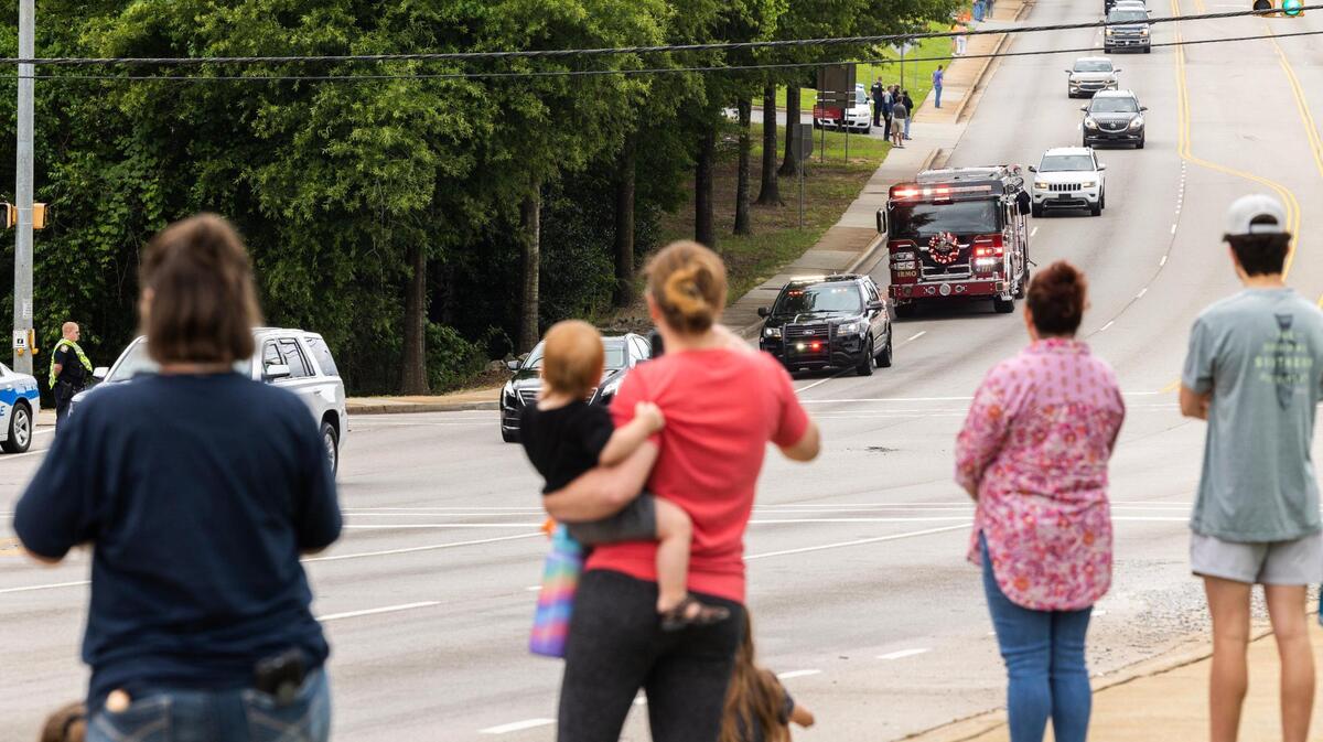 People watch a procession for Firefighter James Muller, who was killed in a structure fire Friday, in Irmo, South Carolina on May 31, 2023. Law enforcement and public safety agencies from around the region followed Muller’s fire company to Riverland Hills Baptist Church.