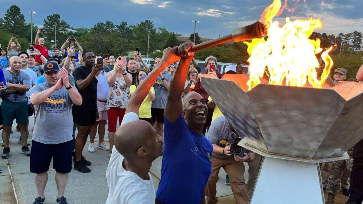 Then-Brig. Gen. Jason Kelly, Fort Jackson commander, and Special Olympics athlete Travis Pringle of Florence, S.C. light the cauldron outside the Solomon Center for the 2023 South Carolina Special Olympics.