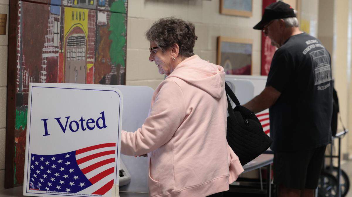Becky Sutusky and Michael Boozer cast their ballots in the municipal election at Hand Middle School on Tuesday, Nov. 4, 2025.