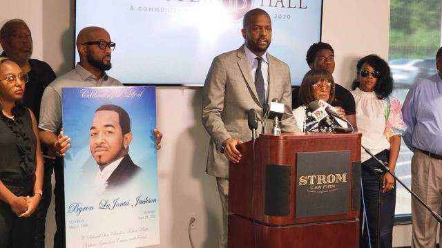 Attorney Barkari Sellers of the Strom Law Firm stands with the family of Byron Jackson during a news conference on July 15, 2025.