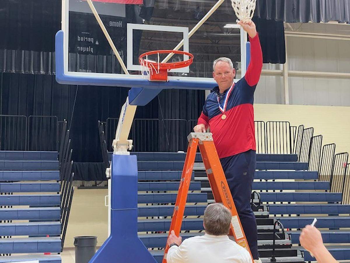 Hilton Head Prep coach Richard Barron holds up the net after the Dolphins won their second straight SCISA Class 3A championship on Saturday, Feb. 24, 2024.