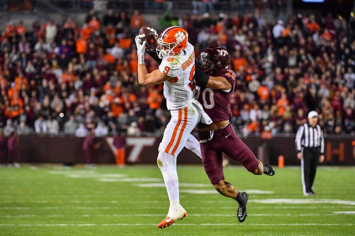 Clemson Tigers tight end Jake Briningstool catches a pass while being defended by Virginia Tech Hokies linebacker Caleb Woodson during the fourth quarter Saturday at Lane Stadium.