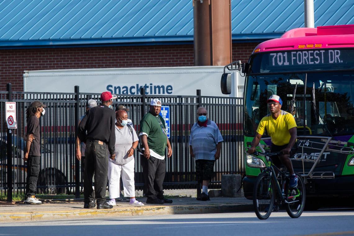 Most people wear masks while waiting for the bus on Sumter Street in downtown Columbia, South Carolina on Friday, June 26, 2020.
