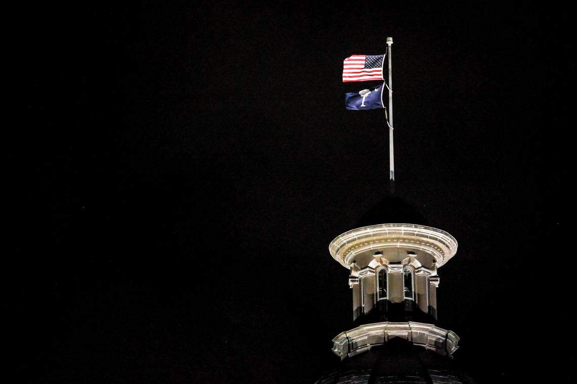 The exterior dome of the South Carolina statehouse is seen at night as flags fly in downtown Columbia, S.C. on Monday, March 7, 2022. (Photo by Travis Bell/STATEHOUSE CAROLINA)