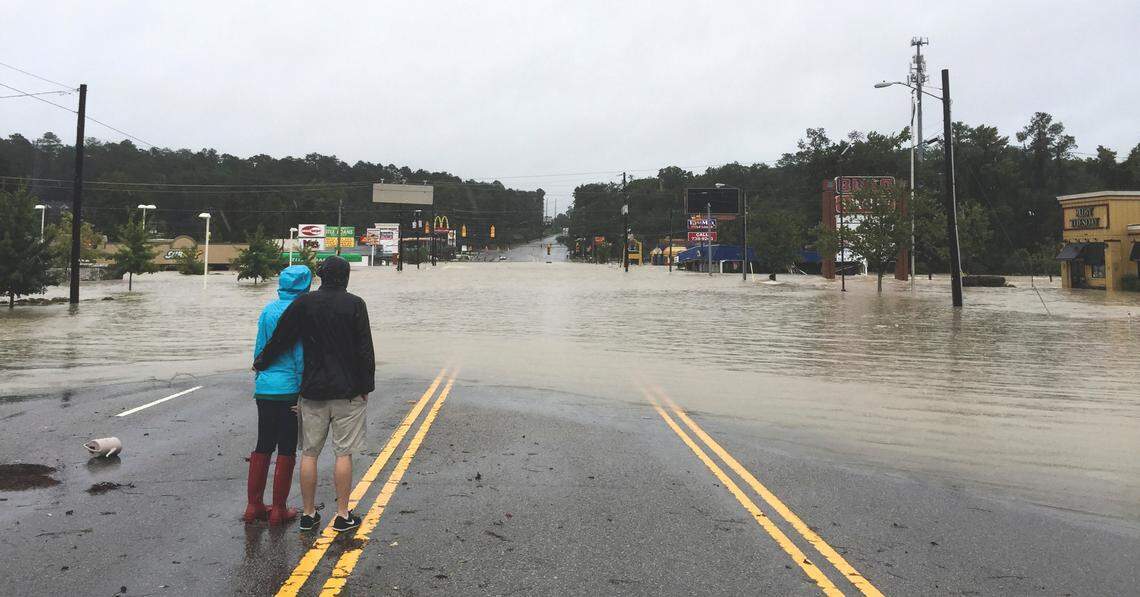 A couple stands in the center of Garners Ferry Road after heavy rains from Hurricane Joaquin caused Gills Creek to overflow its banks on Oct. 4, 2015.