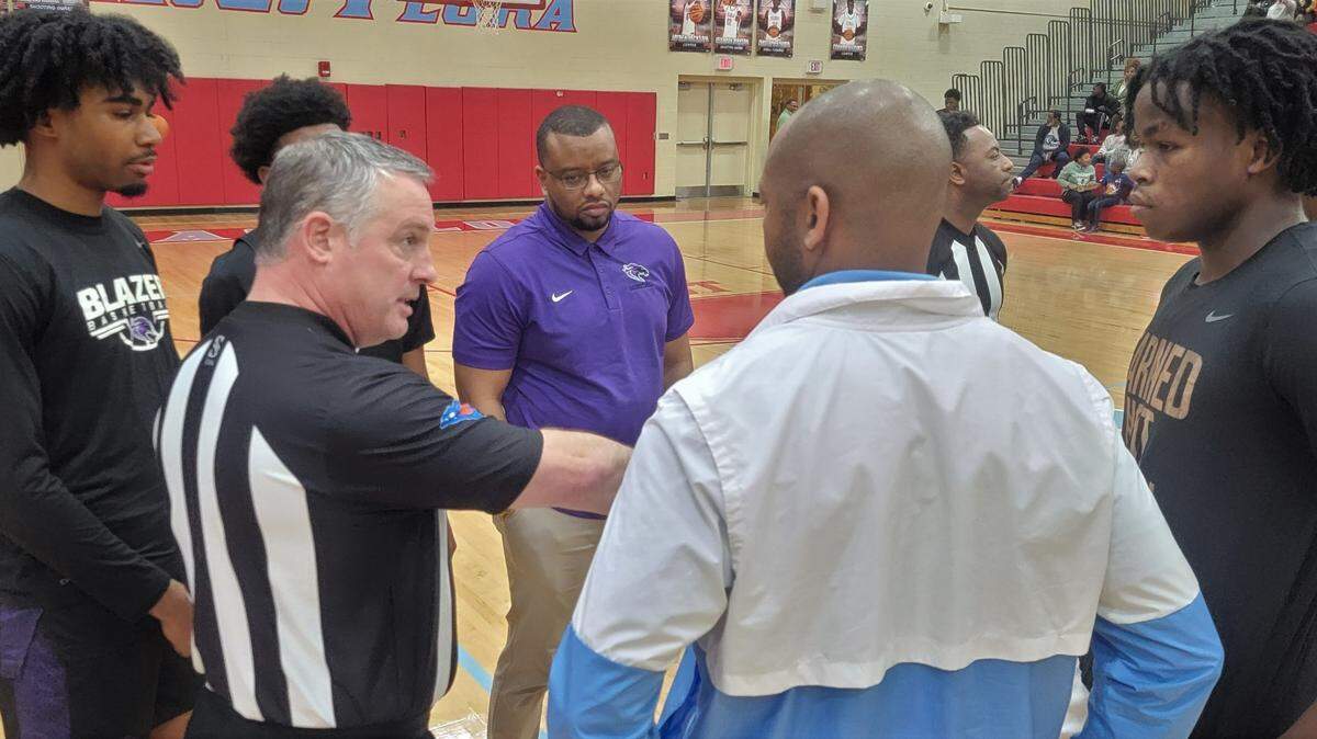 Ridge View coach Joshua Staley, middle, looks on during the pre-game meeting before Tuesday’s game agaiinst AC Flora.