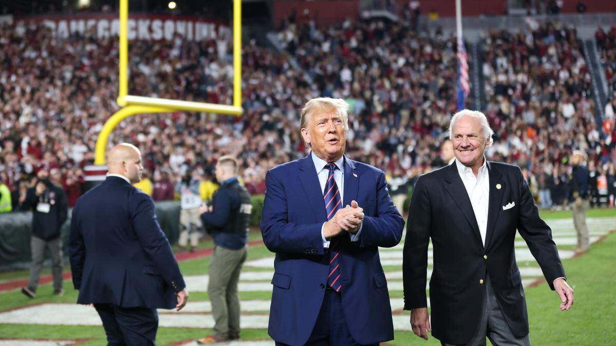 Former President Donald Trump and Governor Henry McMaster walk out onto the field during halftime of South Carolina’s game against Clemson at Williams-Brice Stadium in Columbia on Saturday, November 25, 2023.