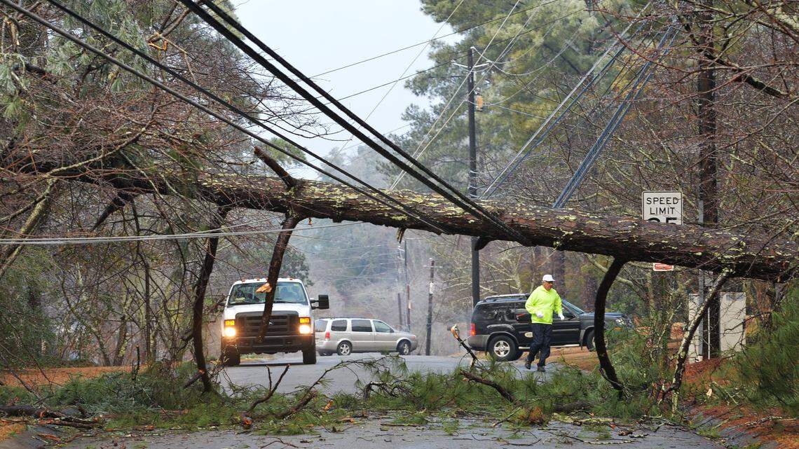 This file photo shows workers attempting to fix downed power lines.
