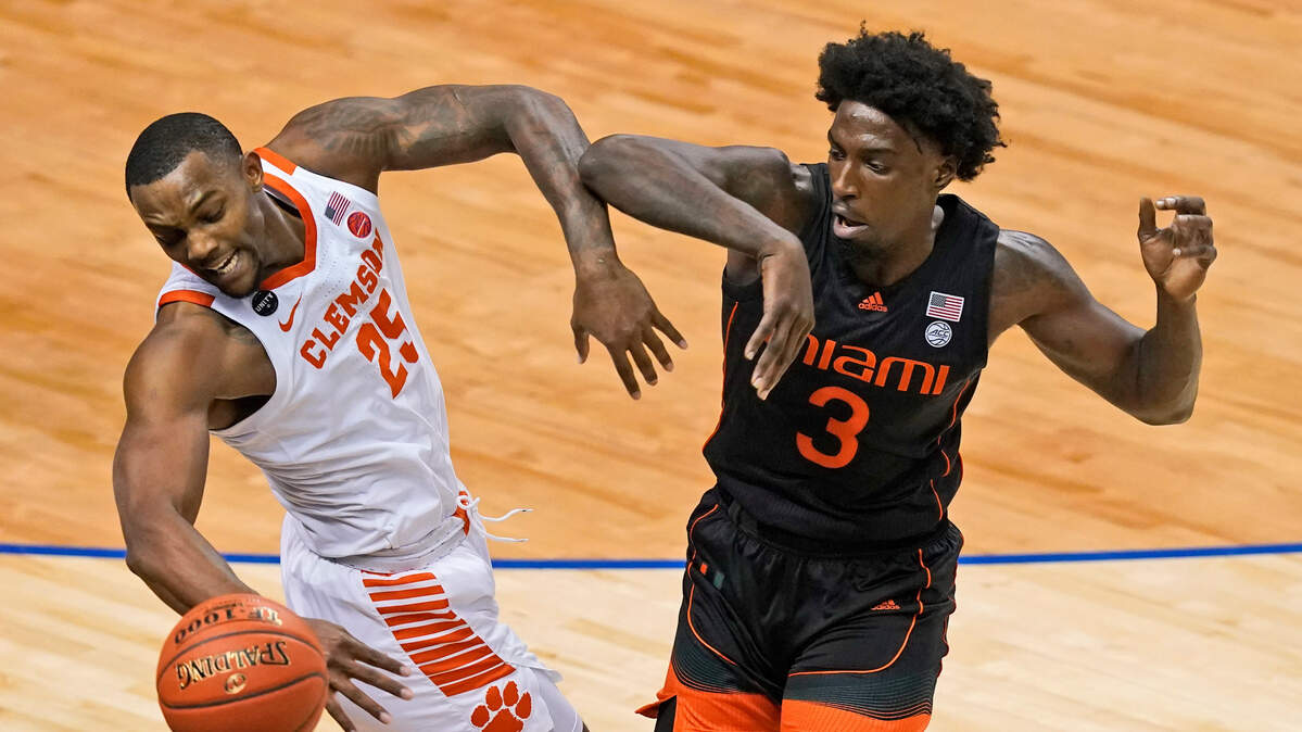 Clemson forward Aamir Simms (25) and Miami center Nysier Brooks (3) battle for a loose ball during the first half of an NCAA college basketball game in the second round of the Atlantic Coast Conference tournament in Greensboro, N.C., Wednesday, March 10, 2021. (AP Photo/Gerry Broome)