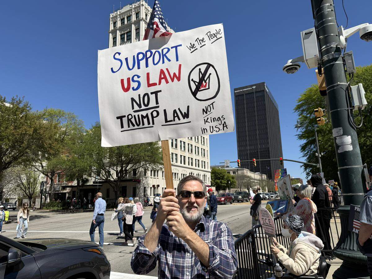 Neal Vernon of Columbia holds aloft an anti-Trump protest sign at Saturday’s No Kings rally at the SC State House.