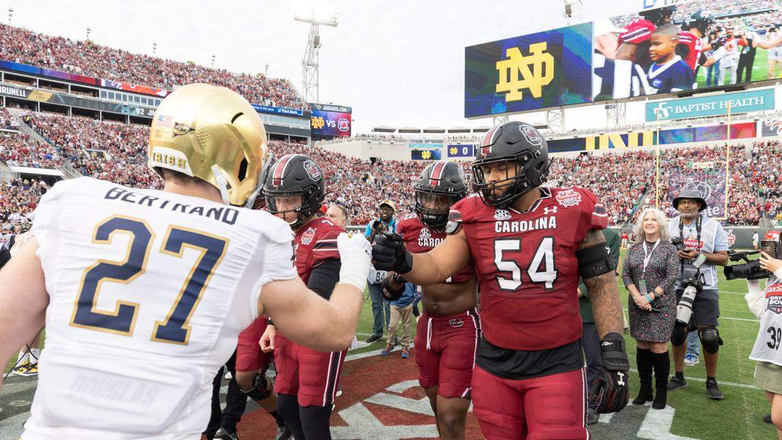 Captains from South Carolina and Notre Dame meet for the coin toss before the Gator Bowl at TIAA Bank Field in Jacksonville, FL on Friday, Dec. 30, 2022.