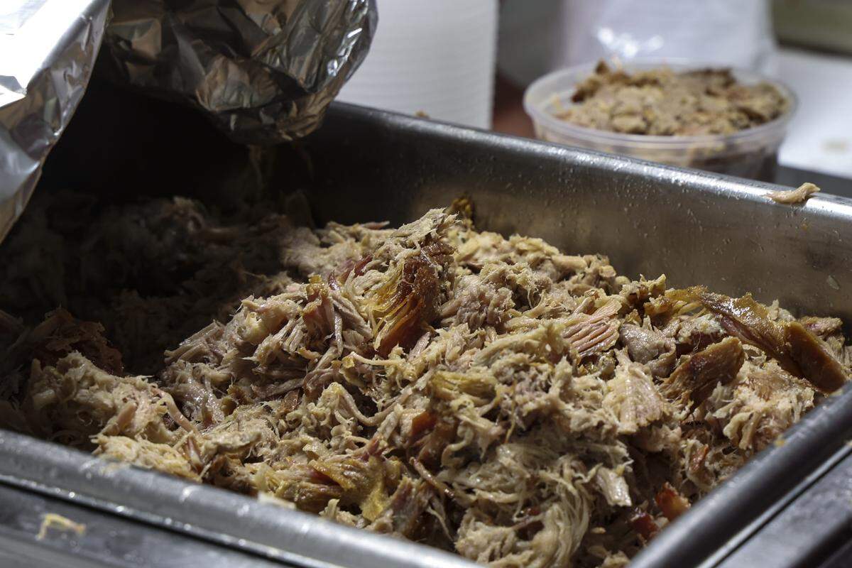 After mixing pork shoulder and pork belly, the pulled pork at Robbie Robinson’s City Limits Barbeque restaurant in West Columbia is portioned into individual containers, ensuring every serving has the correct mixture and is uniformly moist.