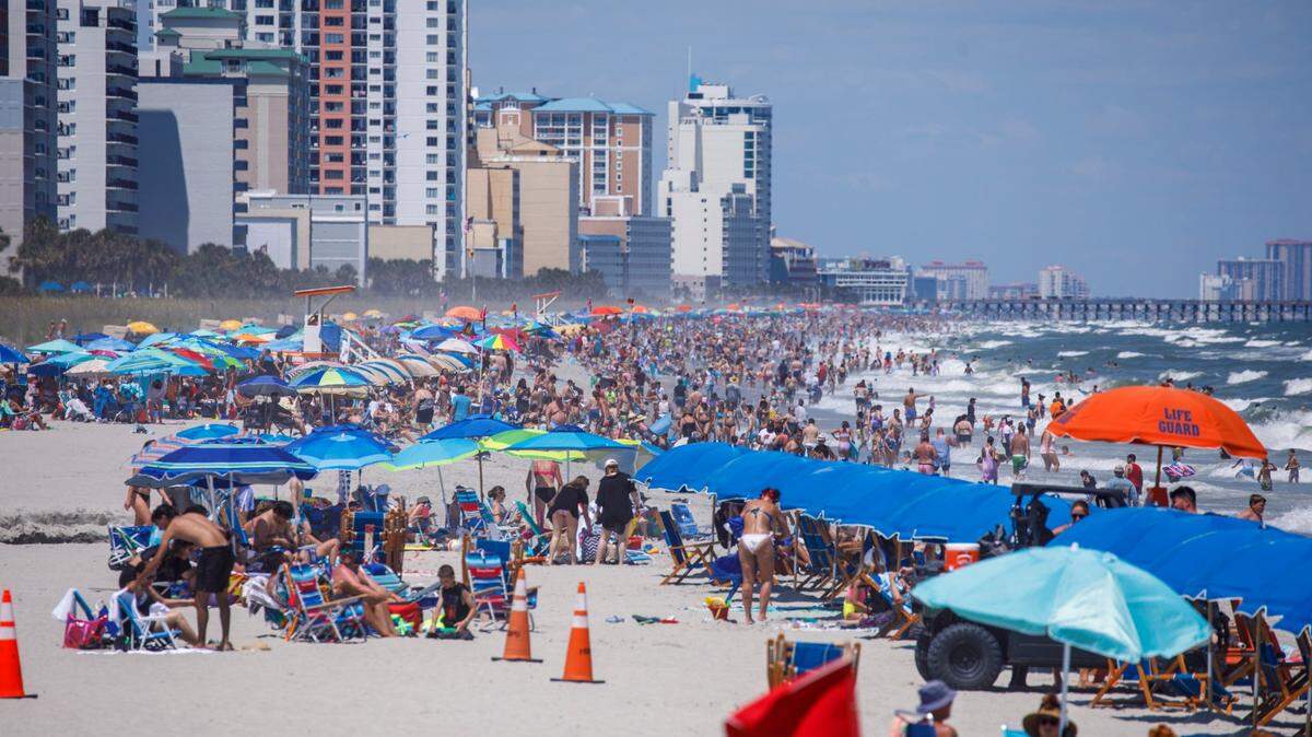 View from the Springmaid Pier looking north at swimmers and sunbathers in Myrtle Beach in July 2024. The resort city draws millions of vacationers. Chemicals from an old air force base were documented in 2026 on the beach near the pier.