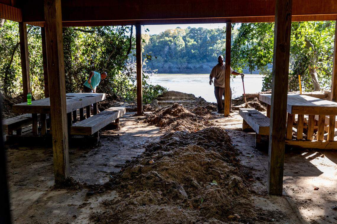 Workers dig you a layer of mud and debris, washed up from the Congaree River, in a shelter at the Cayce Riverwalk where the Congaree River over topped its banks. Heavy rains upstream from Hurricane Helene caused the river to crest at 30.58 feet.