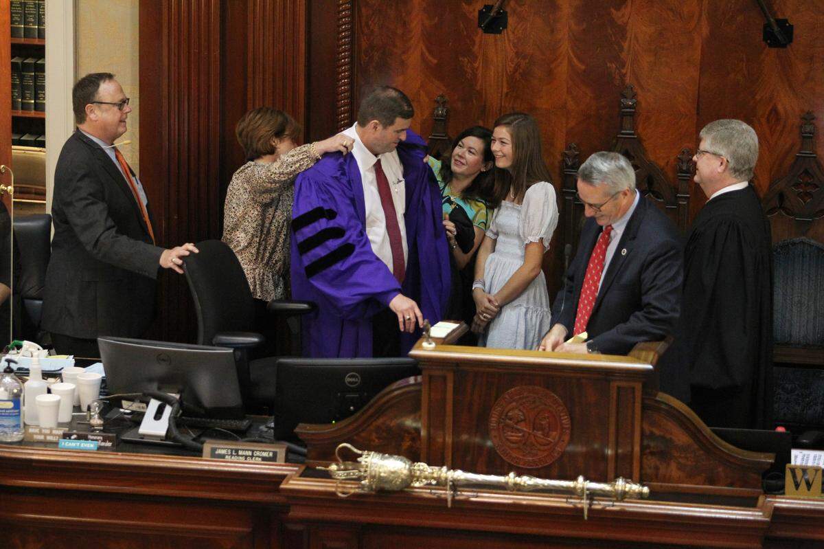 Rep. Murrell Smith gets help from his family with putting on his robe after being sworn in as the new House Speaker during session in Columbia, S.C. on Thursday, April 28, 2022. (Travis Bell/STATEHOUSE CAROLINA)