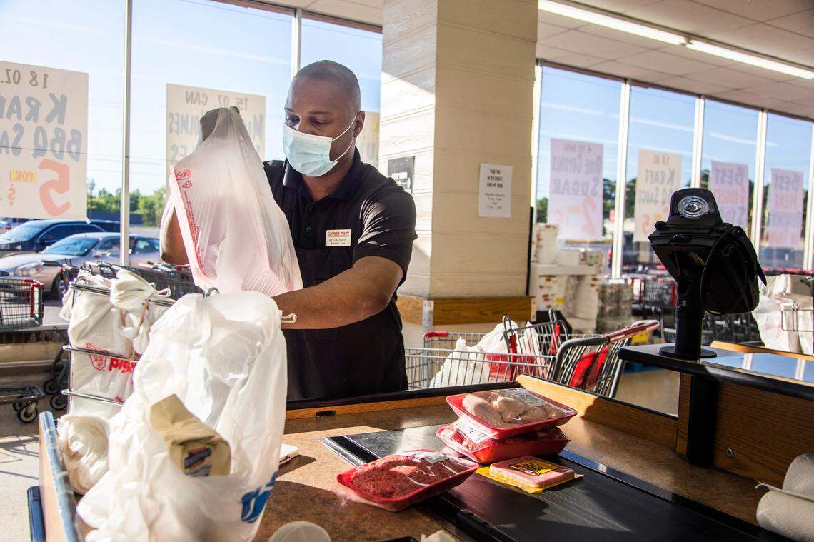 Kelvin Davis, a manager at Piggly Wiggly, bags customer’s groceries on Tuesday, April 28, 2020.