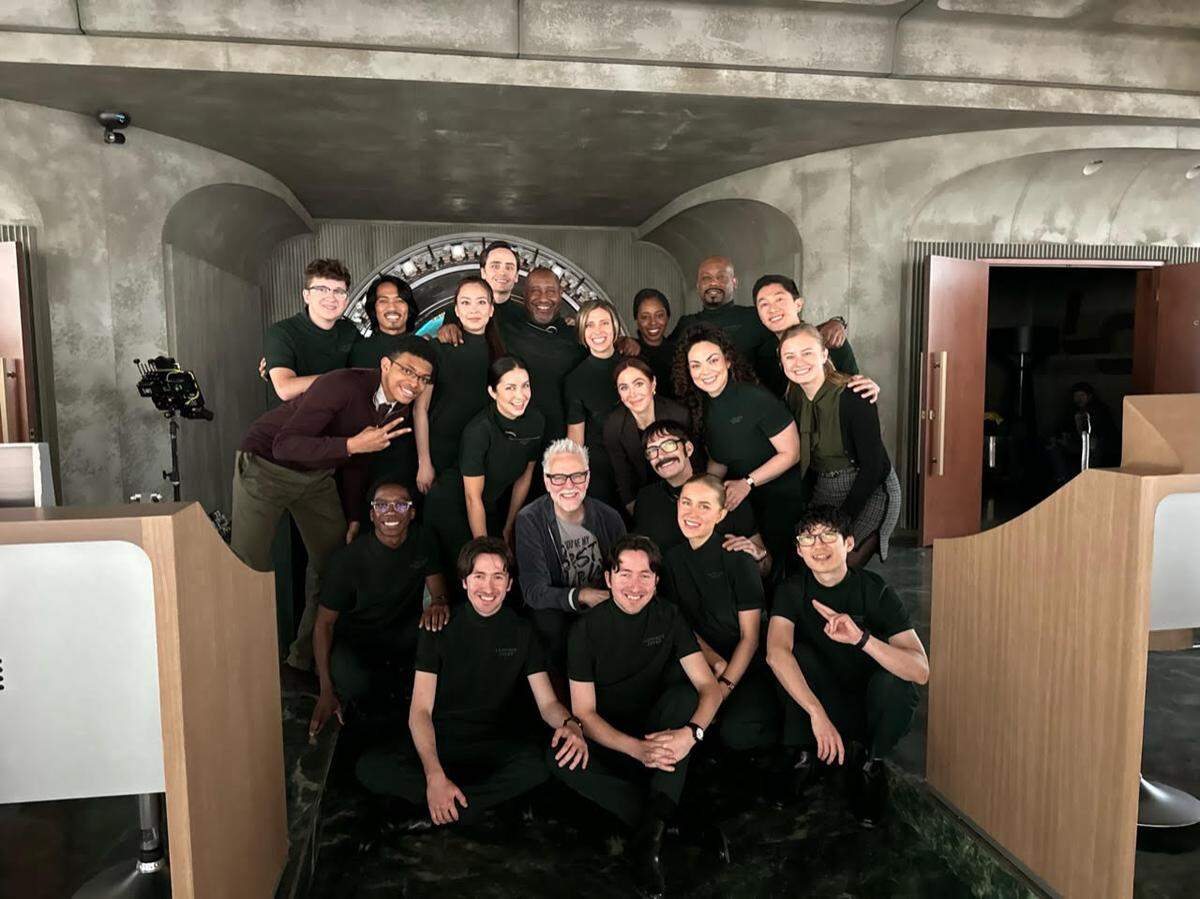 The cast members that were part of Lex Luthor’s control room crew, including Bonnie Discepolo, pose with director James Gunn.