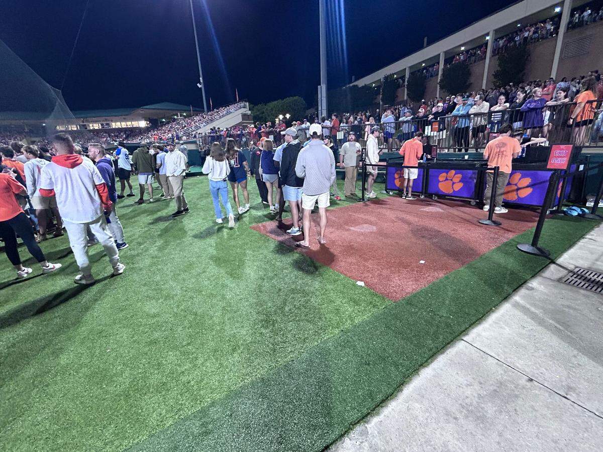 Clemson baseball fans wait in line at a beer stand in left field. This large area used to be the visiting bullpen, and the side-by-side red turf diamonds (where visiting catchers would squat during bullpen sessions) are still visible in the beer garden area.