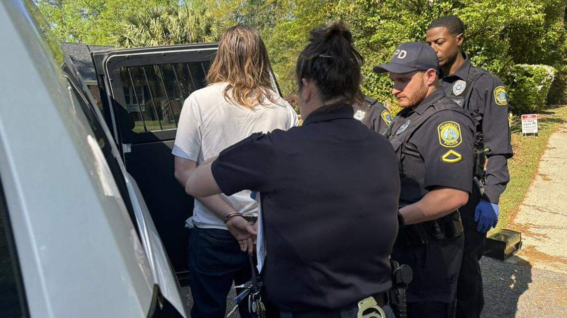 Columbia police officers surround a man in handcuffs following a chase that ended in a crash.