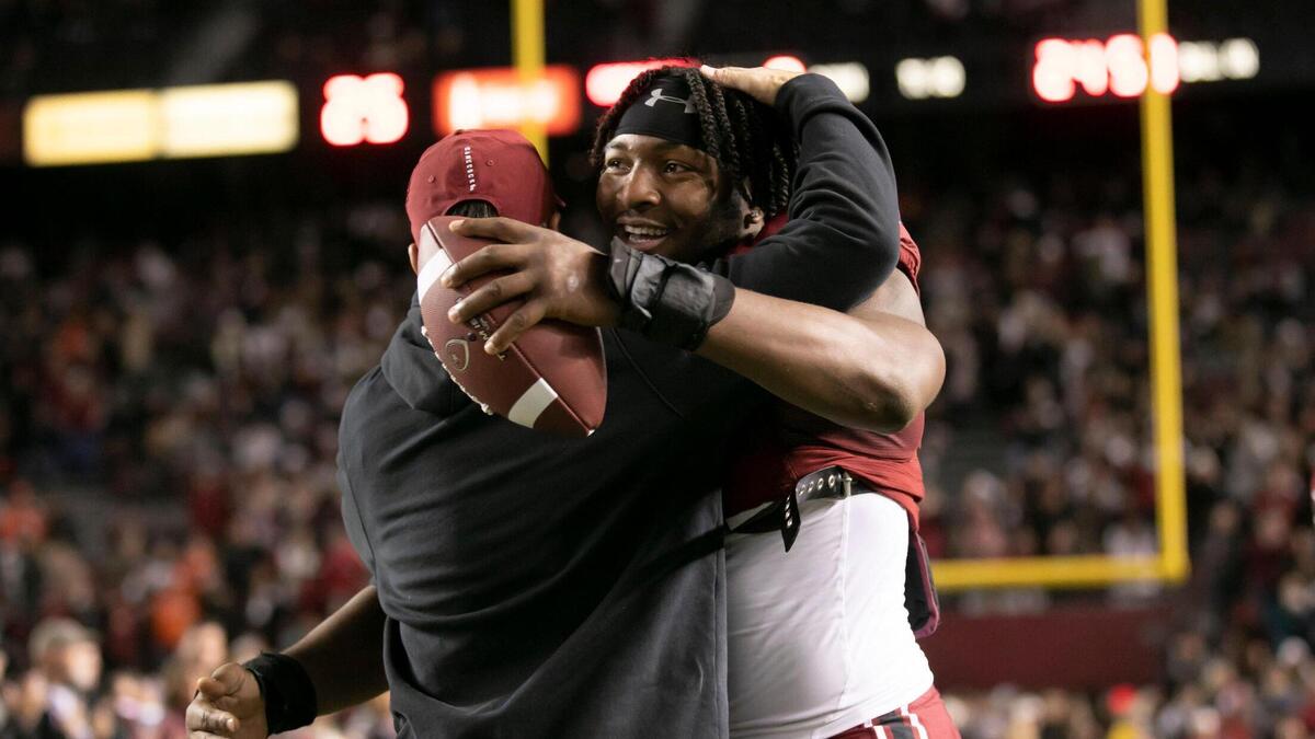 Kingsley “JJ” Enagbare gets a hug from coach Shane Beamer while being recognized on senior night before the Gamecocks’ game against Clemson at Williams-Brice Stadium on Saturday, November 27, 2021.