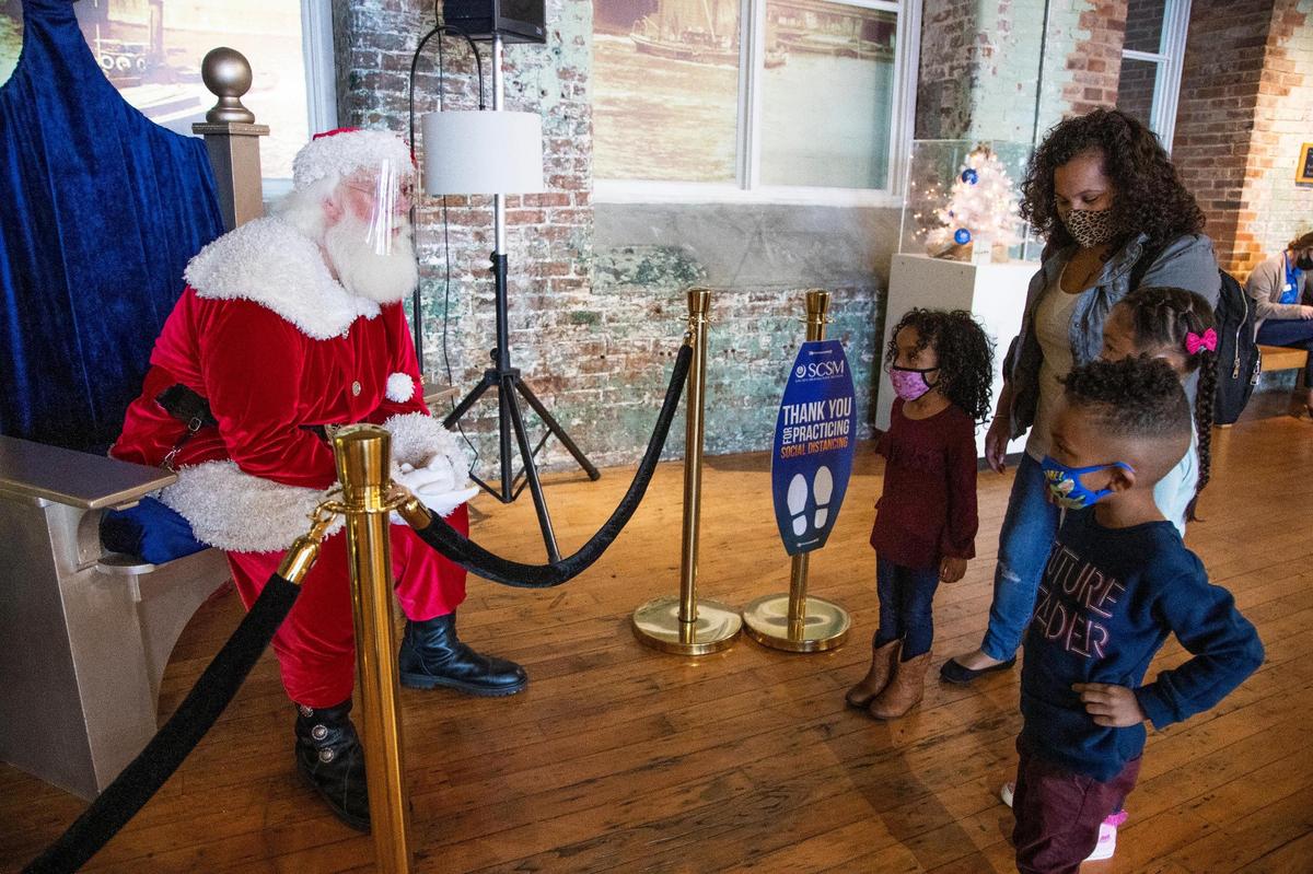 Santa Claus asks the Weathersby family what they want for Christmas at the South Carolina State Museum in Columbia, South Carolina on Saturday, December 12, 2020.