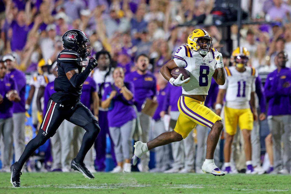 Running back Ju'Juan Johnson #8 of the Louisiana State Tigers runs for 56 yards in the third quarter as defensive back Peyton Williams #31 of the South Carolina Gamecocks gives chase at Tiger Stadium on October 11, 2025 in Baton Rouge, Louisiana.