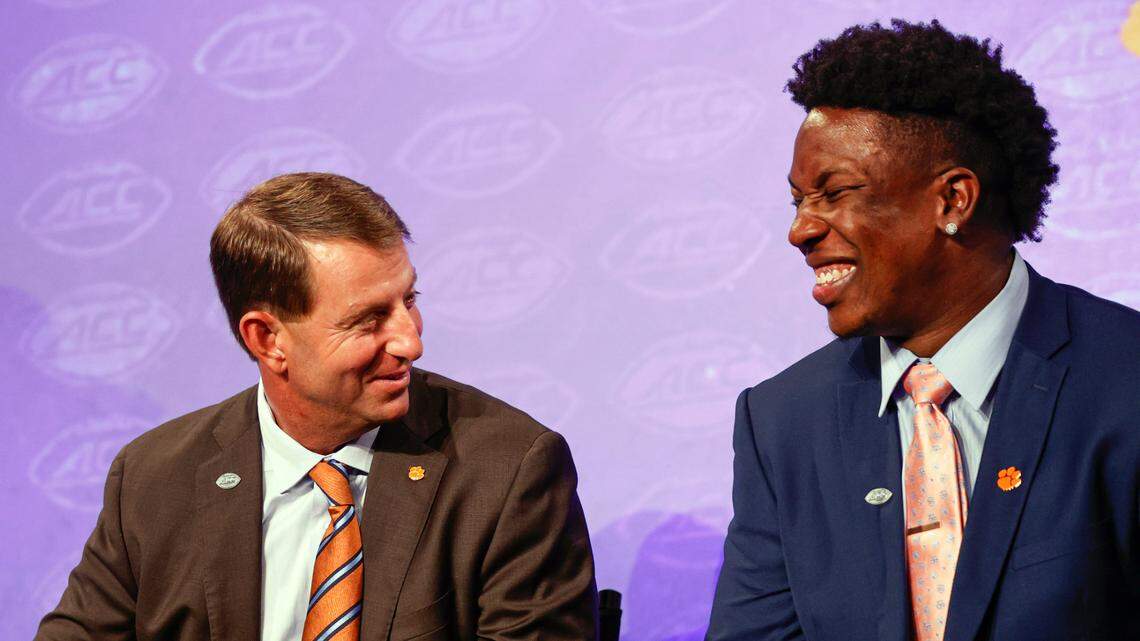 Clemson head coach Dabo Swinney, left, laughs with defensive end K.J. Henry at the NCAA college football Atlantic Coast Conference Media Days in Charlotte, N.C., Wednesday, July 20, 2022. (AP Photo/Nell Redmond)