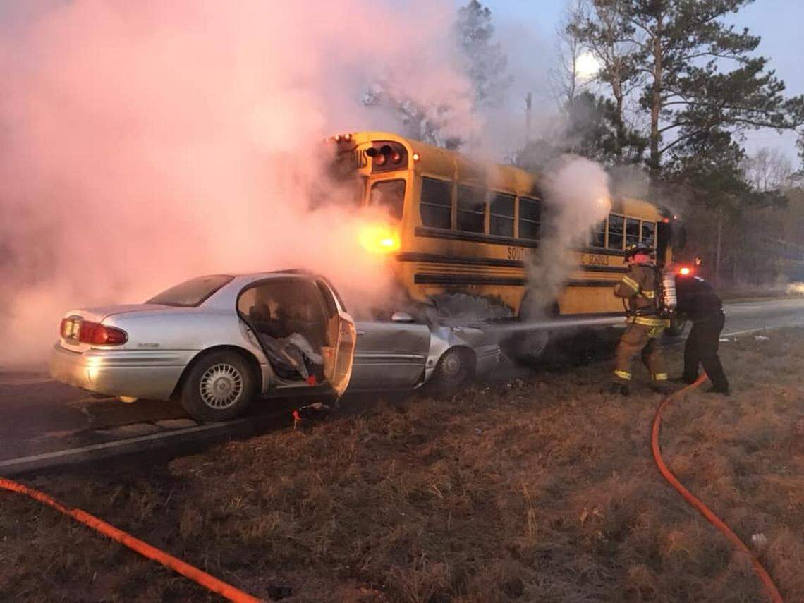 Fire fighters work on putting out a fire that consumed a school bus after a crash in South Carolina.
