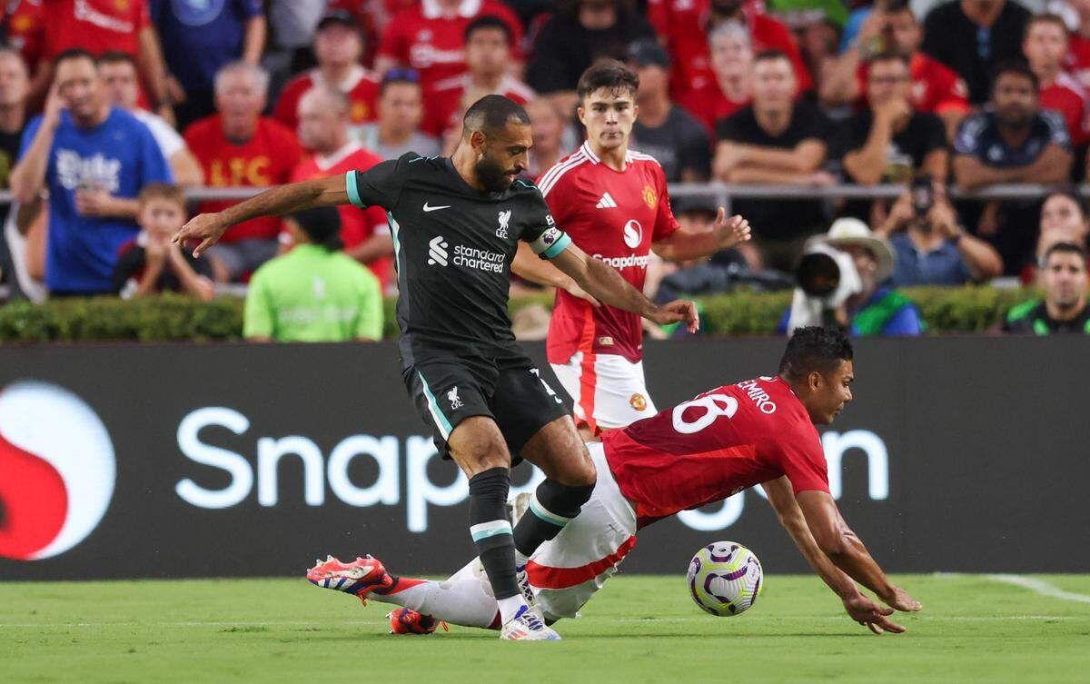 Liverpool forward Mohamed Salah (11) moves the ball up the field as Manchester United midfielder Casemiro (18) hits the ground during the Rivals in Red International Friendly soccer match between Manchester United and Liverpool in Columbia on Saturday, August 3, 2024.