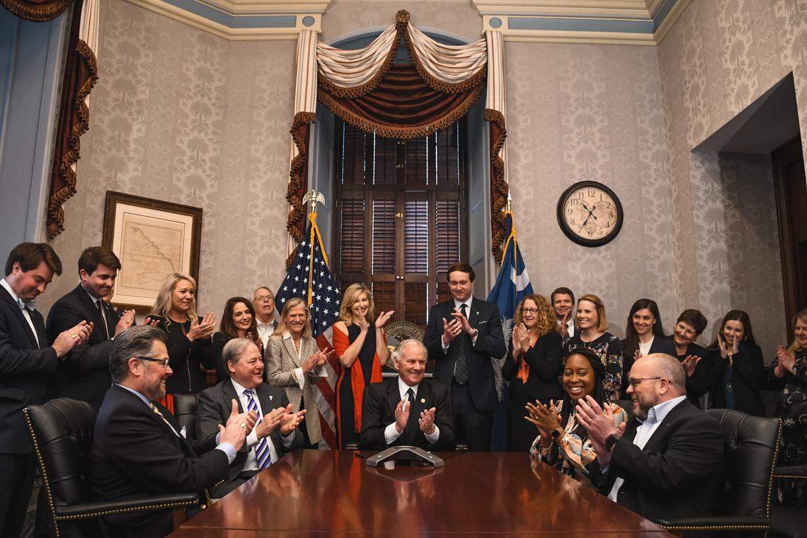 South Carolina Gov. Henry McMaster and members of his team applaud while receiving a call from Scout Motors CEO Scott Keogh announcing the company’s decision to launch an electric vehicle manufacturing plant in Richland County.