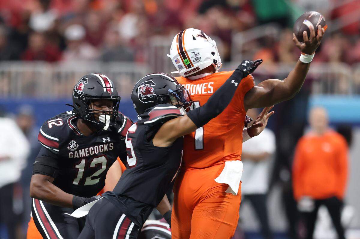 South Carolina defensive back Brandon Cisse (15) pressures Virginia Tech quarterback Kyron Drones (1) Sunday at Mercedes-Benz Stadium in Atlanta. The Gamecocks and Hokies faced off Aug. 31 in the 2025 Aflac Kickoff Game.