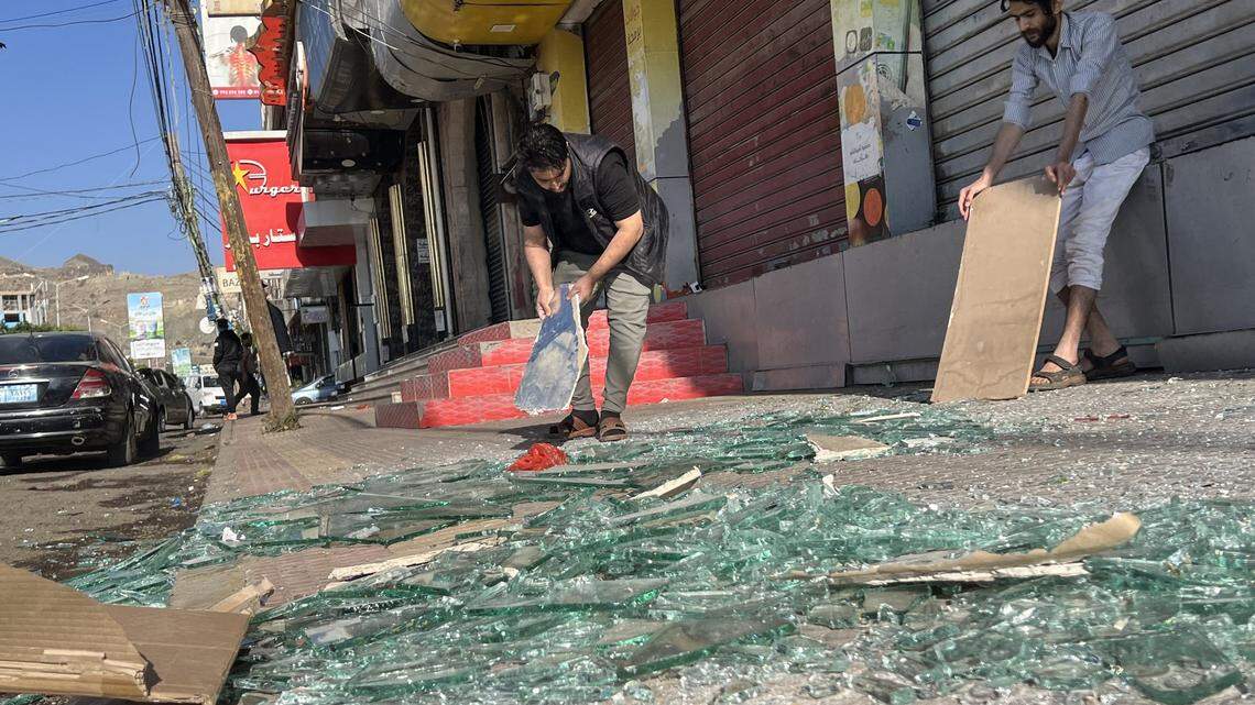 Yemenis clear rubble in front of their stores on March 16, 2025, after U.S. airstrikes in Sanaa. President Donald Trump ordered massive attacks on the Iran-backed Houthi militia in several Yemeni provinces, including Sanaa.
