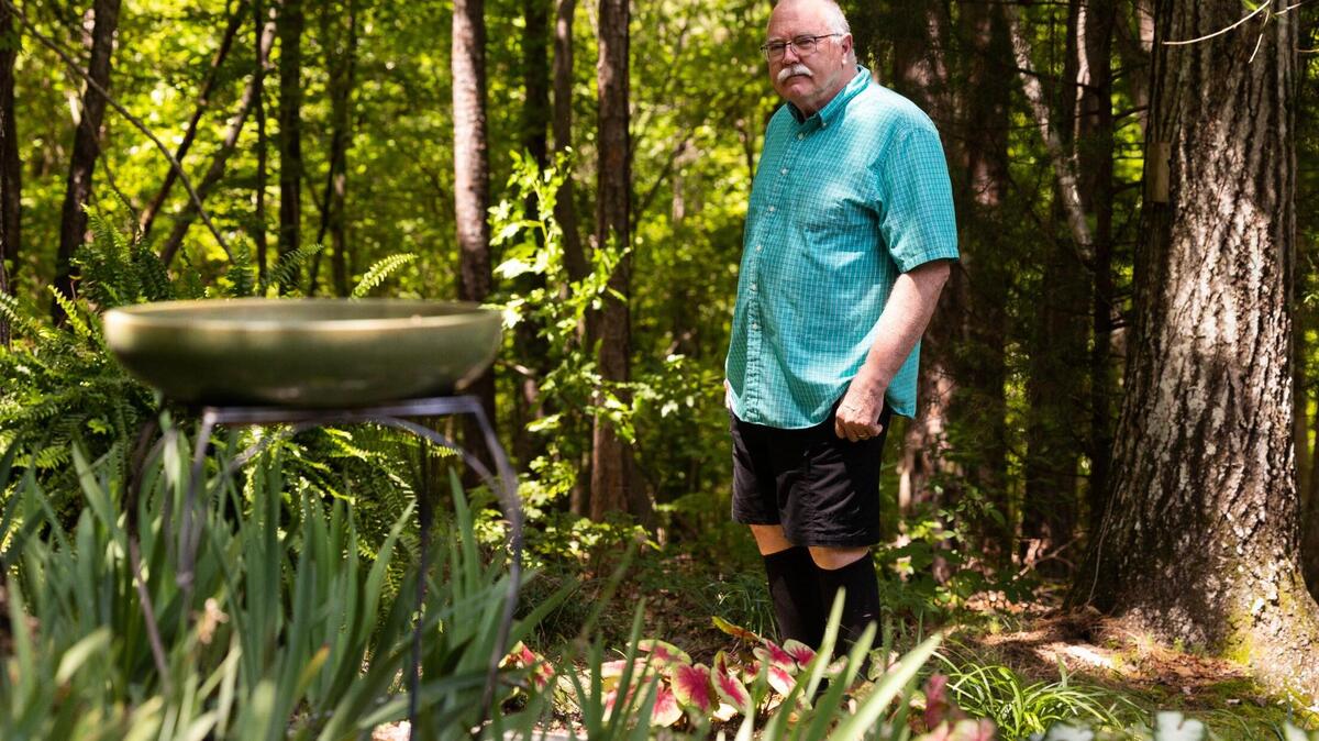 Gordon Fuller, who lives in the Ashely Oaks Phase I development, shows where his property ends and the property owned by Scout Motors starts on Wednesday, June 14, 2023.